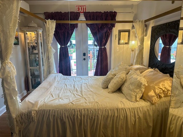 bedroom featuring ornamental molding, access to exterior, hardwood / wood-style flooring, and french doors