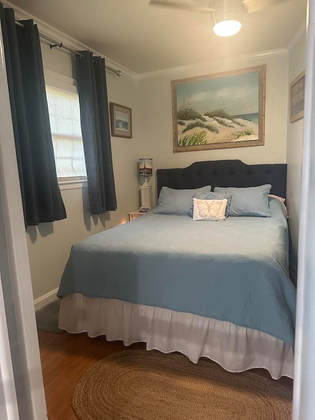 bedroom featuring ceiling fan, crown molding, and wood-type flooring