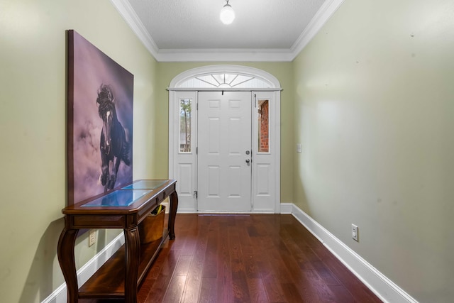 foyer entrance featuring a textured ceiling, ornamental molding, and dark wood-type flooring