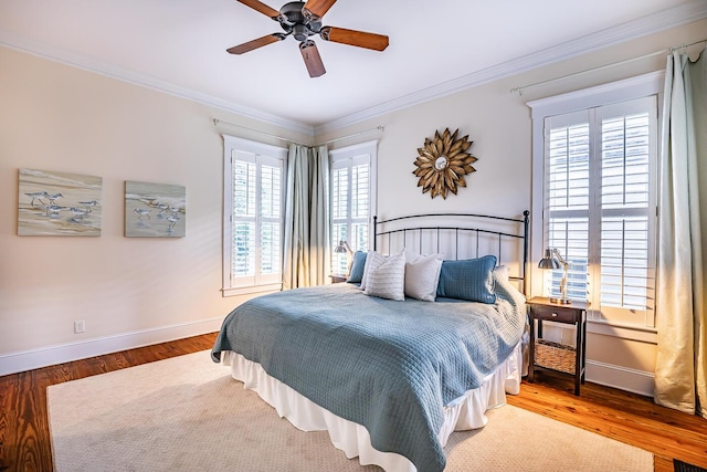 bedroom with ceiling fan, ornamental molding, and wood-type flooring