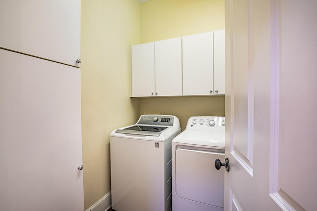 laundry area featuring washer and dryer and cabinets