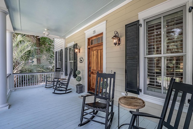 wooden terrace with a porch and ceiling fan