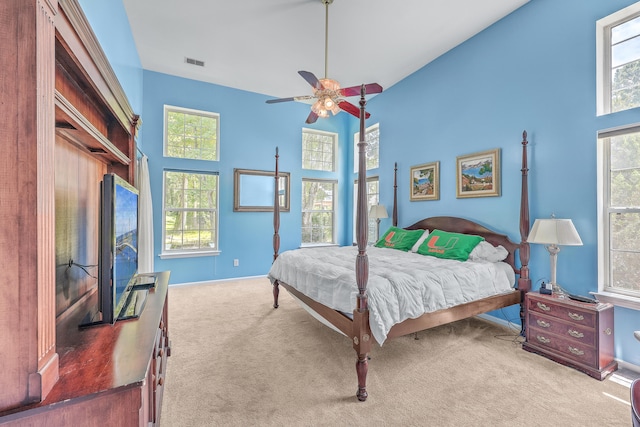 carpeted bedroom with a high ceiling and ceiling fan