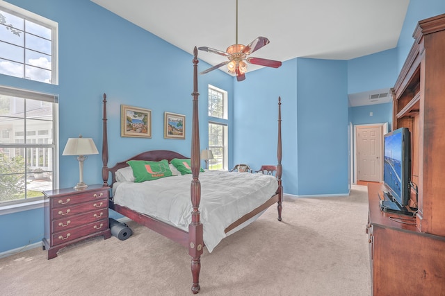 carpeted bedroom with high vaulted ceiling and ceiling fan