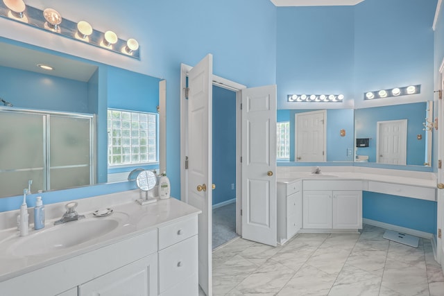 bathroom with vanity, a high ceiling, and an enclosed shower