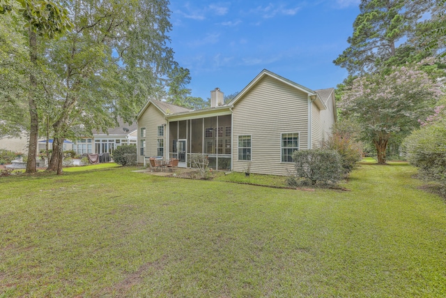 back of house with a yard, a patio, and a sunroom