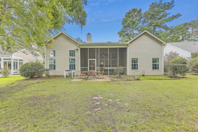 back of property featuring a sunroom, a patio area, and a lawn