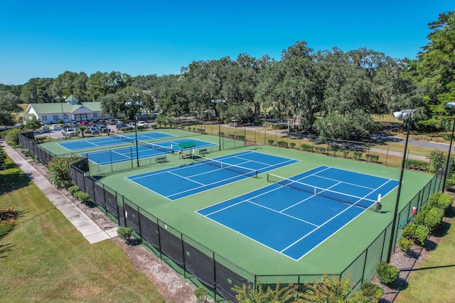 view of sport court with a lawn and basketball hoop