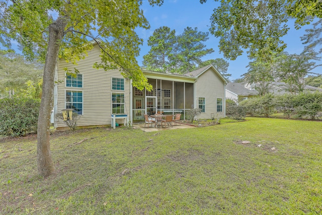 rear view of house featuring a sunroom, a patio area, and a lawn