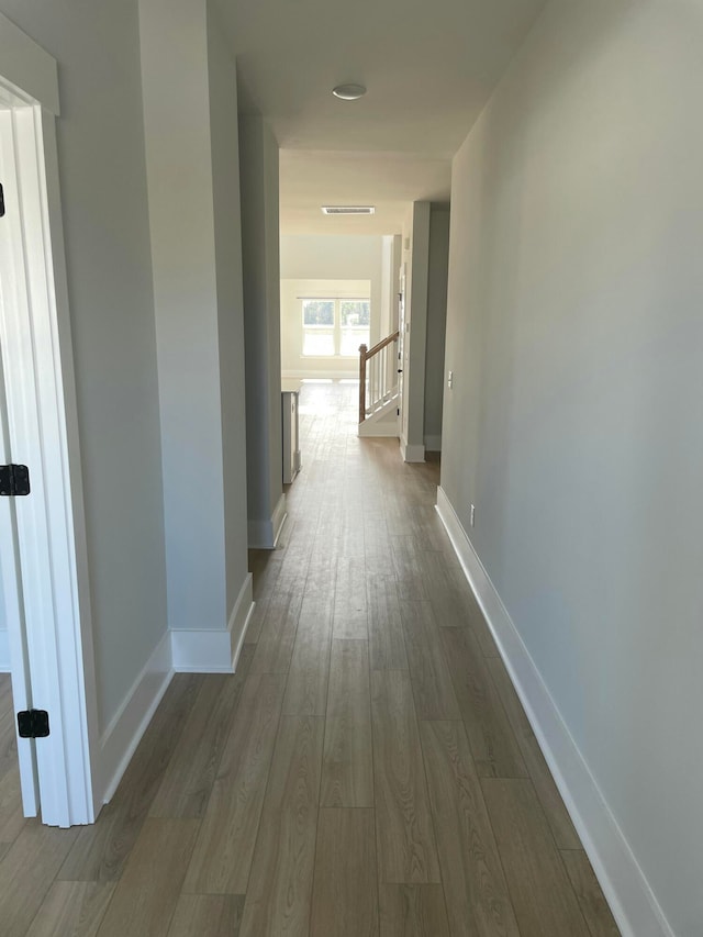 corridor with hardwood / wood-style flooring