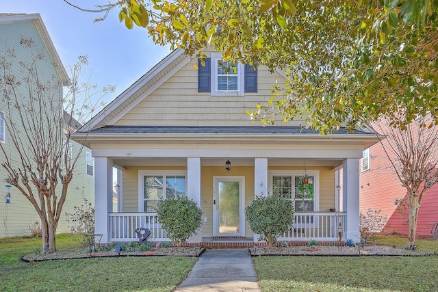 bungalow with a front yard and covered porch