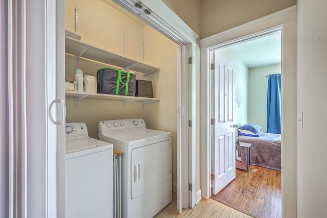 laundry area featuring washer and clothes dryer, laundry area, and light wood-type flooring