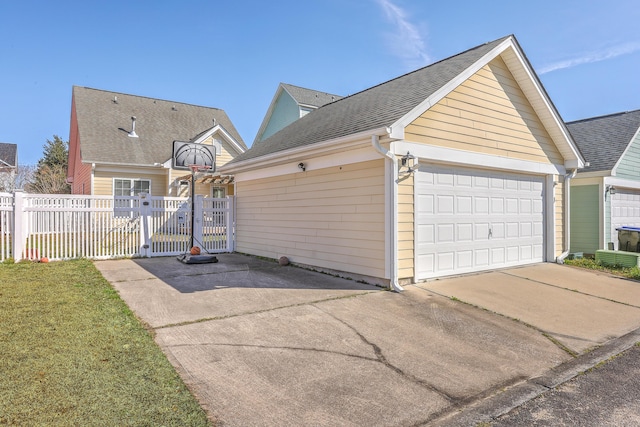 view of front facade with fence, a garage, and roof with shingles