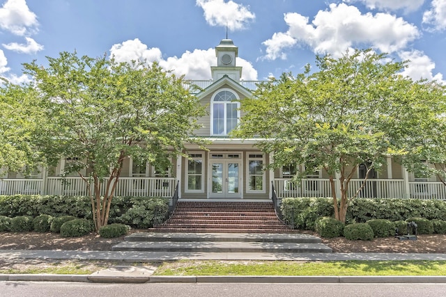 entrance to property with a porch and french doors