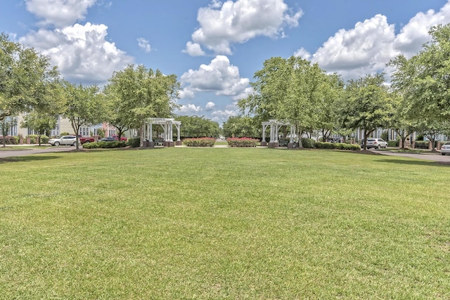 view of home's community featuring a yard and a pergola