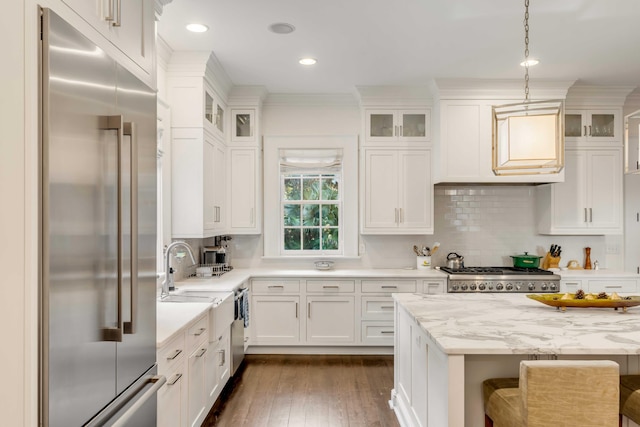 kitchen featuring decorative light fixtures, a kitchen bar, light stone countertops, and stainless steel appliances