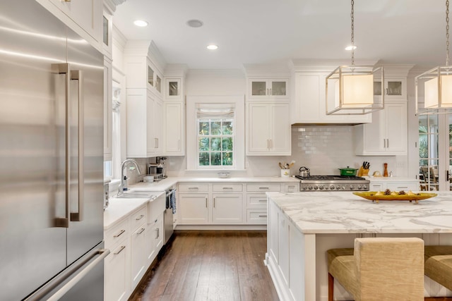 kitchen featuring hanging light fixtures, a kitchen breakfast bar, tasteful backsplash, dark hardwood / wood-style flooring, and appliances with stainless steel finishes