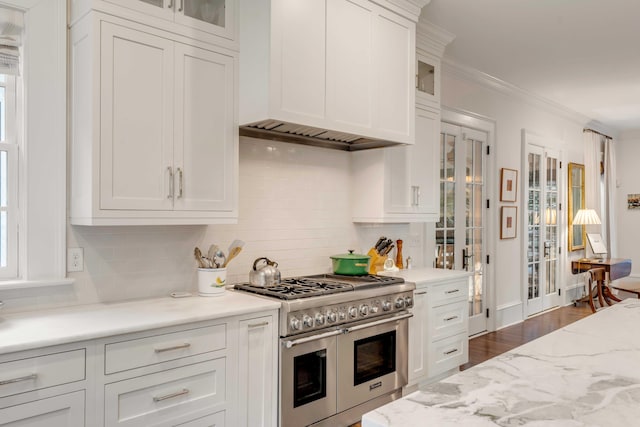 kitchen featuring dark hardwood / wood-style floors, backsplash, crown molding, double oven range, and white cabinets