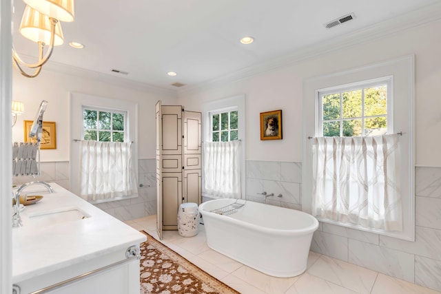 bathroom featuring a bath, vanity, plenty of natural light, and tile walls