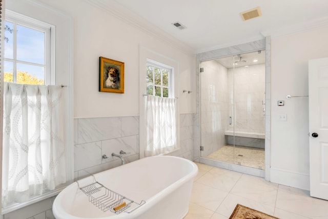 bathroom featuring a healthy amount of sunlight, ornamental molding, tile walls, and separate shower and tub