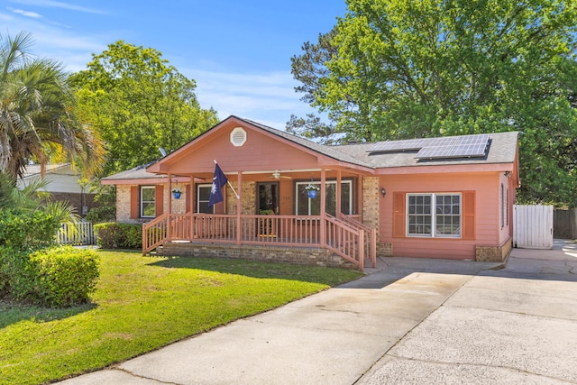 1593 Westwood Dr, Charleston, SC 29412 - view of front of home with covered porch, roof mounted solar panels, a shingled roof, driveway, and brick siding
