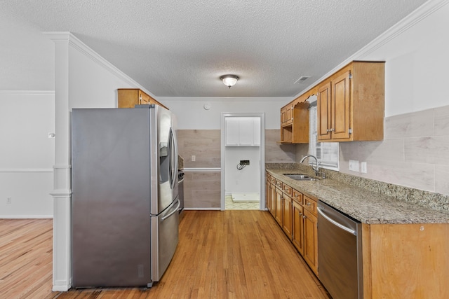 1593 Westwood Dr, Charleston, SC 29412 - kitchen with appliances with stainless steel finishes, a sink, light wood-style floors, a textured ceiling, and light stone countertops