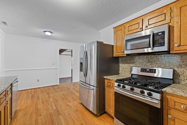 1593 Westwood Dr, Charleston, SC 29412 - kitchen featuring stainless steel appliances, crown molding, brown cabinets, and a textured ceiling