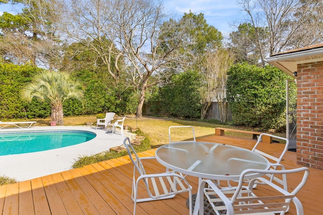 view of swimming pool featuring a lawn, a fenced in pool, a fenced backyard, outdoor dining area, and a deck