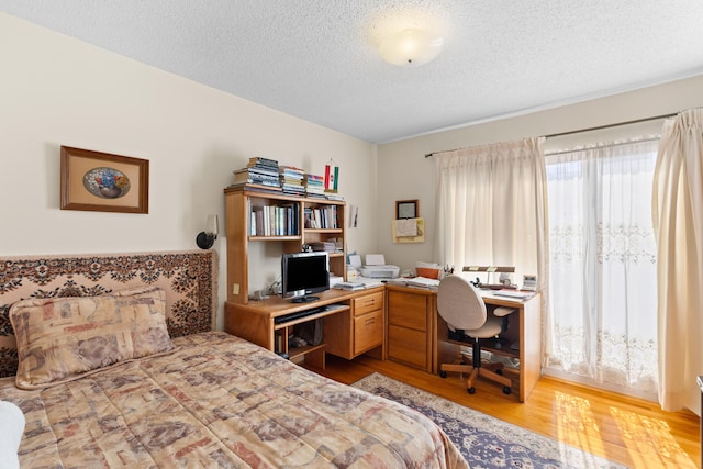 bedroom featuring light wood-style floors and a textured ceiling