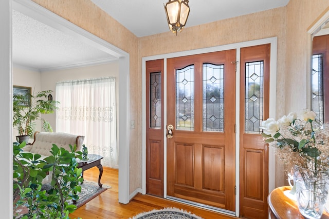 entryway with a textured ceiling and light wood finished floors