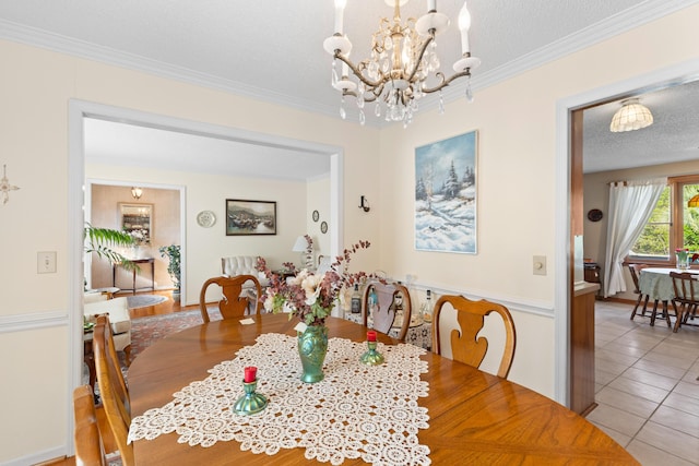 dining area with crown molding, a textured ceiling, an inviting chandelier, and tile patterned floors