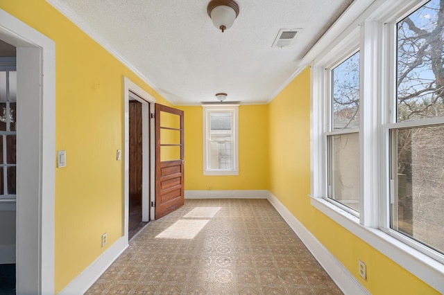 interior space with a healthy amount of sunlight, visible vents, a textured ceiling, and baseboards