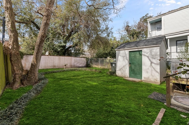 view of yard with an outbuilding, a fenced backyard, and a shed