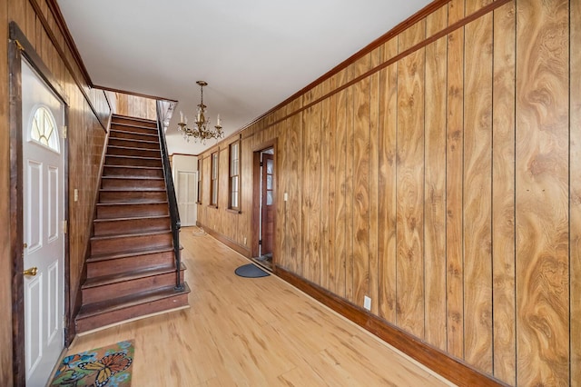 interior space with wooden walls, stairs, and crown molding