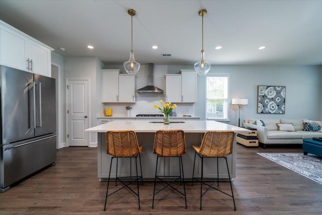 2017 Geranium Ln, Johns Island, SC 29455 - kitchen featuring high end fridge, wall chimney range hood, light countertops, a kitchen island with sink, and white cabinets