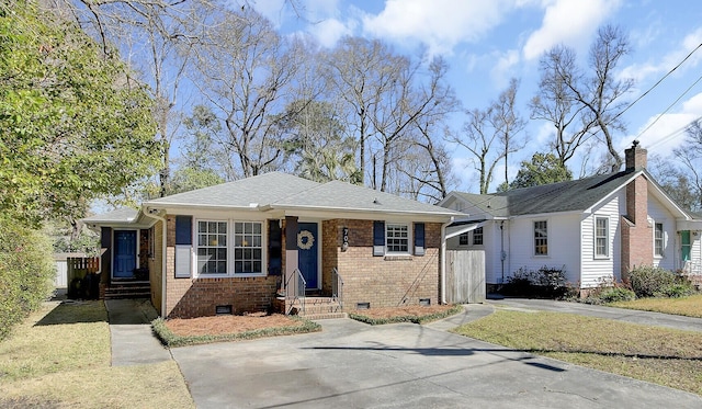 bungalow-style home featuring brick siding, crawl space, a shingled roof, and a front yard