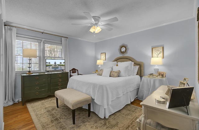 bedroom featuring light wood-style floors, ceiling fan, and ornamental molding