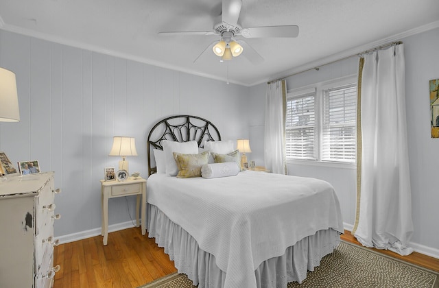 bedroom with ornamental molding, light wood finished floors, a ceiling fan, and baseboards