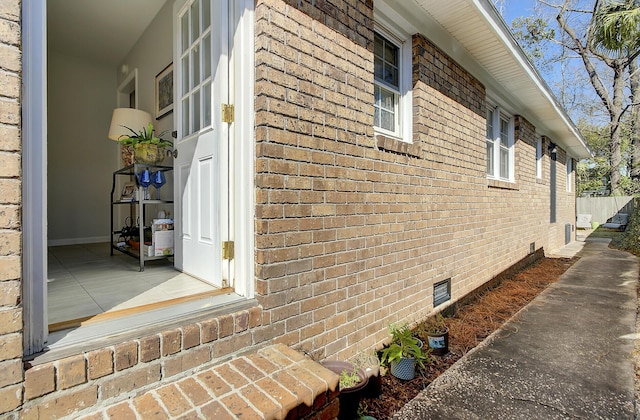 view of property exterior with crawl space and brick siding