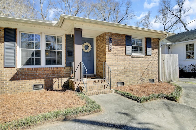 doorway to property with crawl space and brick siding