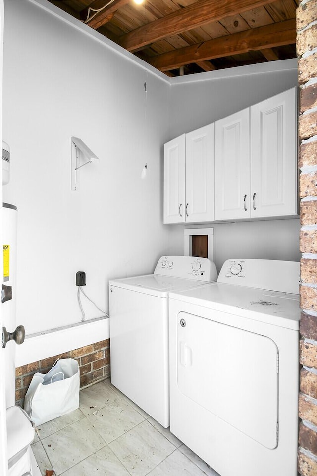 clothes washing area with brick wall, wood ceiling, cabinet space, and washing machine and clothes dryer