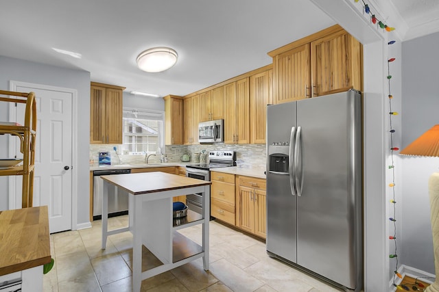 kitchen with light tile patterned flooring, stainless steel appliances, a sink, light countertops, and decorative backsplash