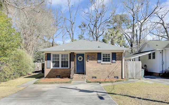 bungalow-style house with crawl space, driveway, a shingled roof, and brick siding