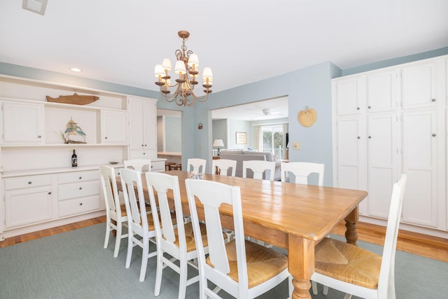 dining area featuring light wood-style floors, recessed lighting, and a chandelier