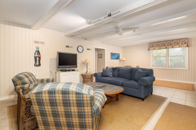 living area featuring a ceiling fan, beamed ceiling, visible vents, and tile patterned floors