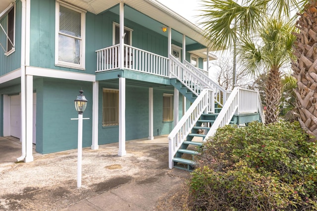 view of property featuring a garage and stairway