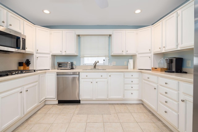 kitchen with light tile patterned floors, stainless steel appliances, a sink, and light countertops