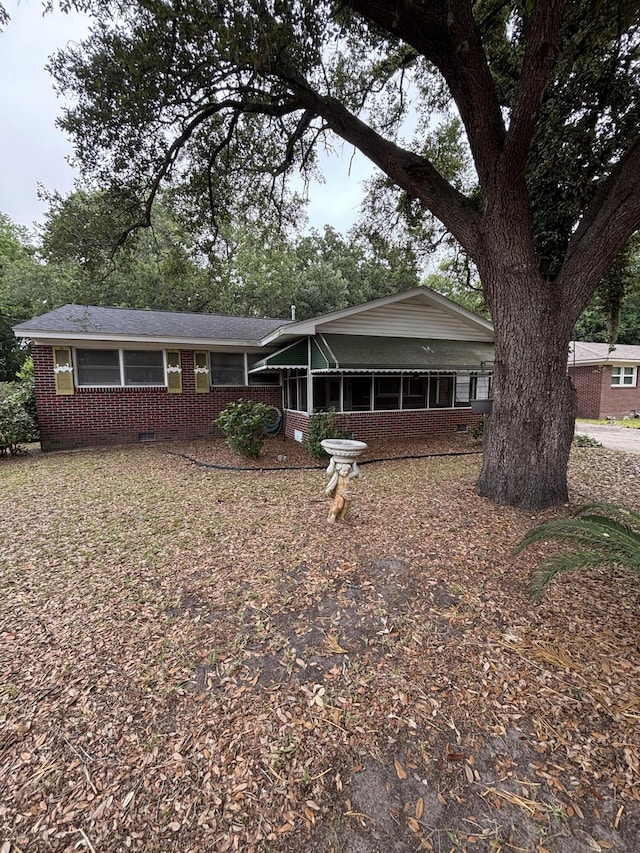 ranch-style home featuring brick siding, crawl space, and a sunroom