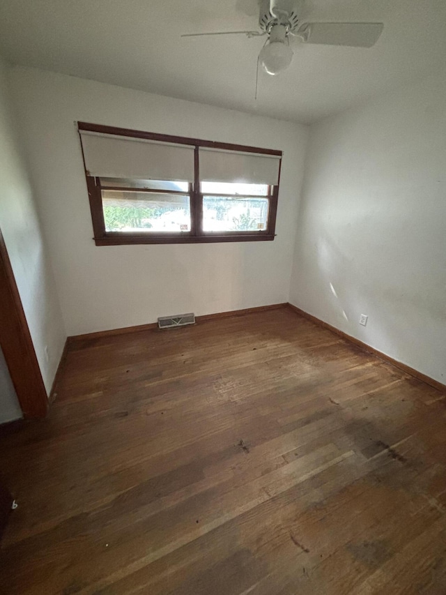 unfurnished room featuring hardwood / wood-style floors, a ceiling fan, and baseboards