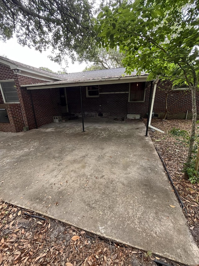back of property with brick siding and an attached carport
